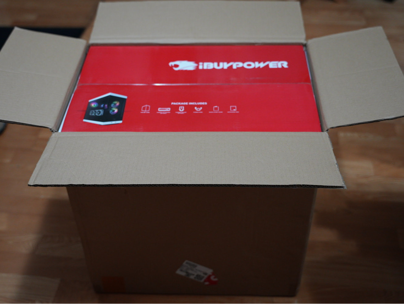 打開的棕色紙箱內裝有iBUYPOWER紅色產品盒