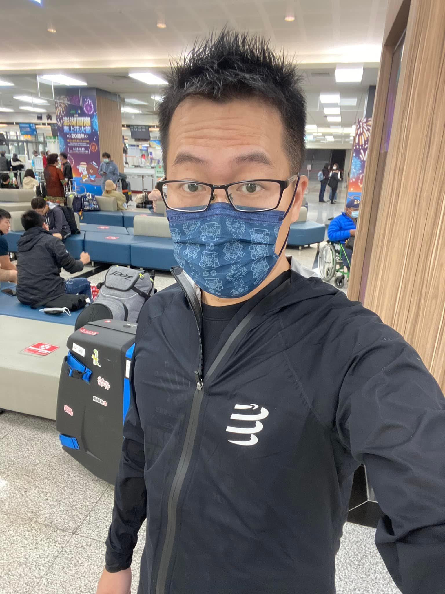 戴口罩眼鏡的男子與行李箱在機場候機室