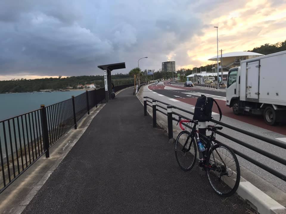 黑色單車停在沖繩沿海公路旁，傍晚海景