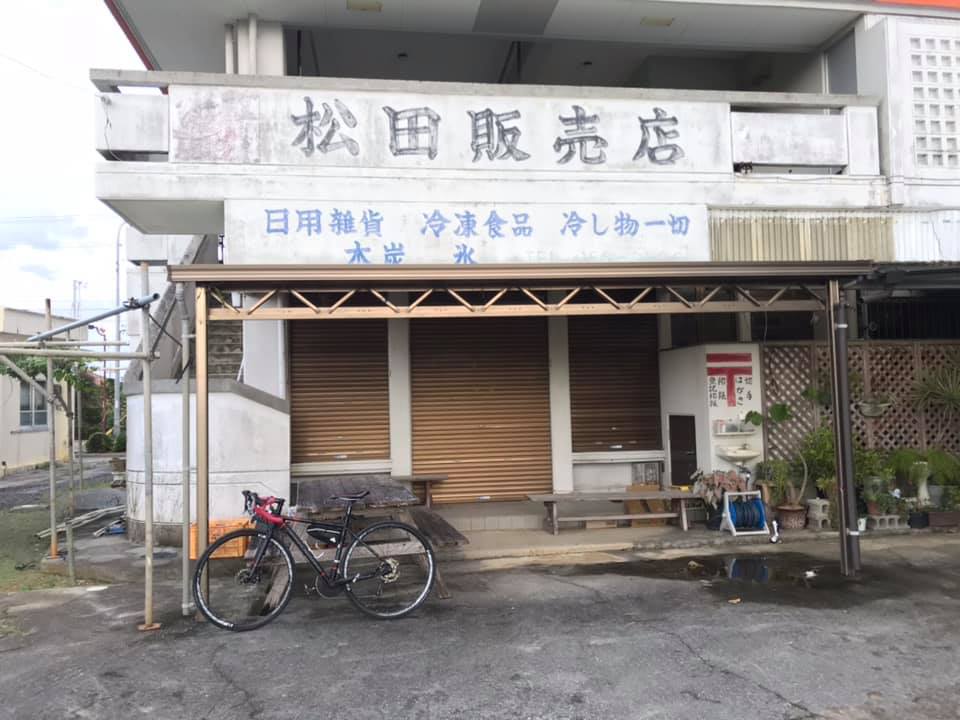 黑色公路車停在沖繩老舊雜貨店前